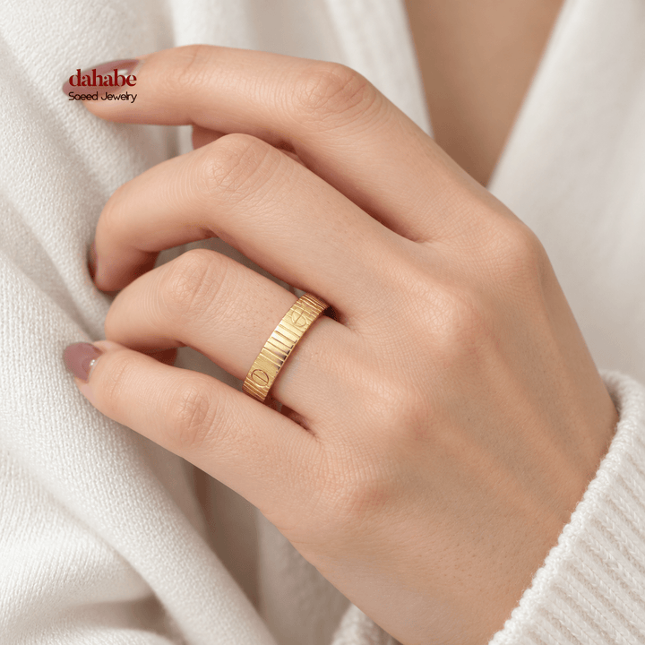 AI-generated try-on simulation of an 18K gold ring with vertical ridges and round screw motifs, shown on a woman&