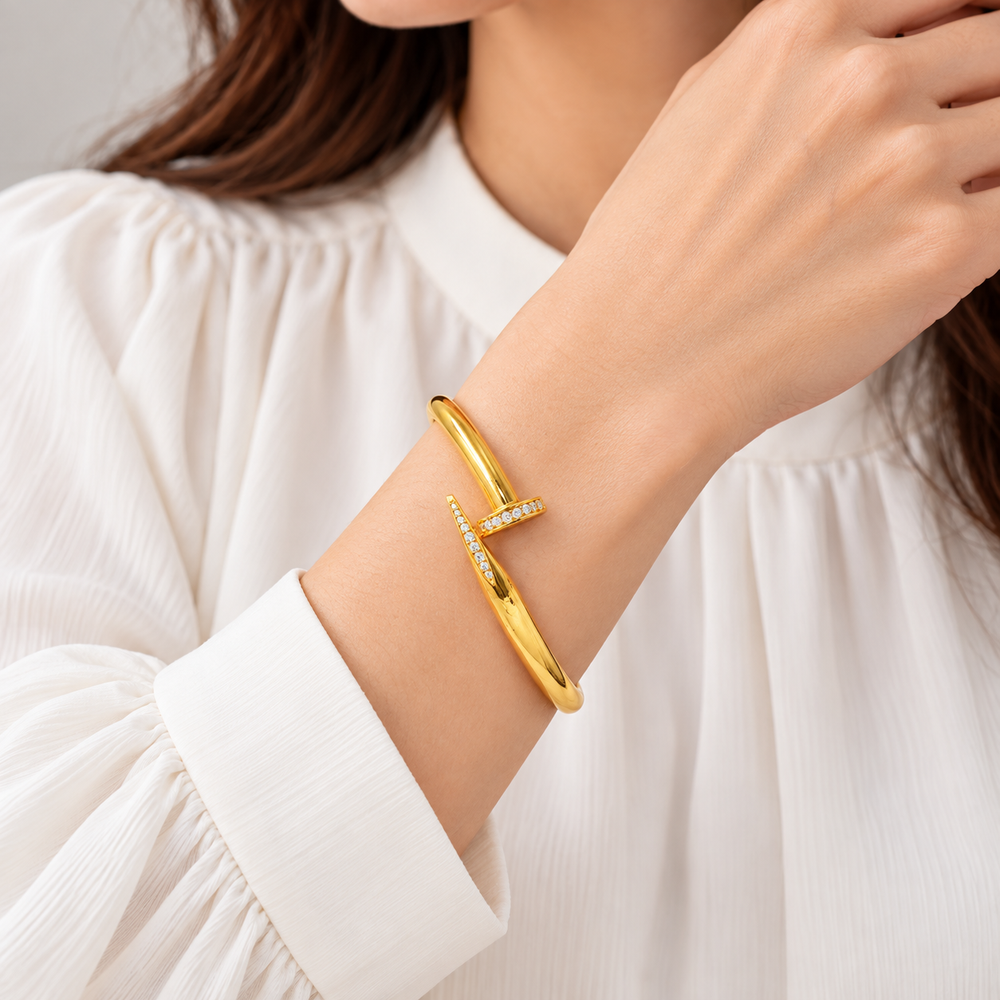 AI-generated try-on of a 21K yellow gold zircon-studded nail bangle bracelet on a model’s wrist
